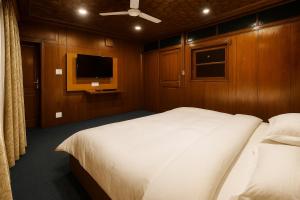 a bedroom with a bed and a flat screen tv at HAYAT Group OF Houseboats in Srinagar