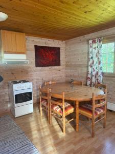 a dining room with a table and a stove at Hafslo hytteutleige Straumane in Luster