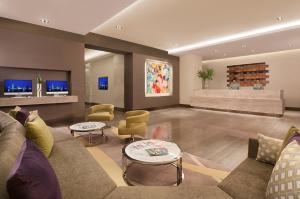 a living room with a couch and chairs at Citadines Salcedo Makati in Manila