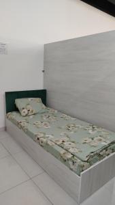 a bed in a room with a white wall at Em capsule Hostel Baku in Baku