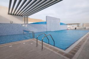a large swimming pool with blue tiles on the wall at Central Inn Al Sadd Suites Hotels in Doha