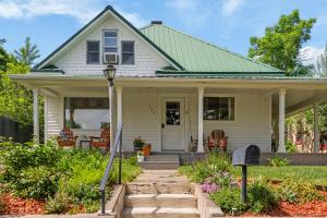 a white house with a green roof at 7th Street Bungalow in Livingston