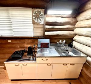 a kitchen with a stove and a clock on the wall at Lodge Kurokawa 1 in Minamioguni
