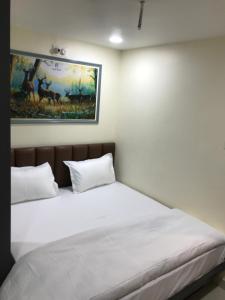 a bed in a room with a painting on the wall at Hotel keshri Nandan in Nāgaur