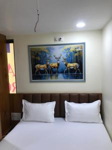 a bedroom with a bed with a painting on the wall at Hotel keshri Nandan in Nāgaur