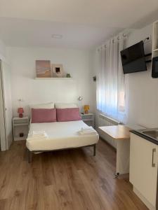 a bedroom with a bed with two pink pillows at Casa Adrianykenia in San Martín de Laspra
