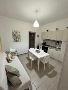a living room with a white table and a kitchen at Appartamenti la terrazza in Pachino