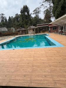 a large swimming pool with blue water in a yard at Sungava homestay in Mirik