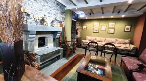 a living room with a couch and a fireplace at Casona El Gurugu in Luarca