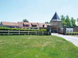 una granja con una valla y un campo con un edificio en camping de la mottelette en Forest-Montiers