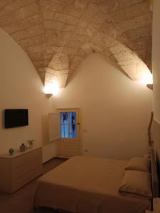 a bedroom with a bed and a tv on a wall at Il rifugio barocco in Lecce