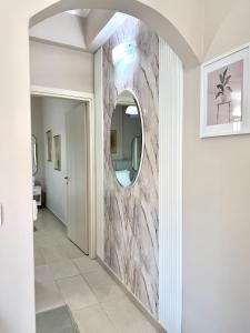 a hallway with a marble wall with a mirror at Aiginetan Apartments in Egina +33 photos