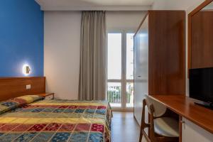 a hotel room with a bed and a television at Hotel Paradiso in Senigallia +21 photos