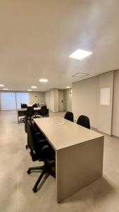 an office with desks and chairs in a room at Apartamento completo e elegante no centro de Pouso Alegre in Pouso Alegre +53 photos