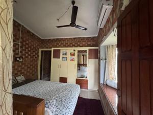 a small bedroom with a bed and a ceiling fan at The Brick Nest in Perumpāvūr