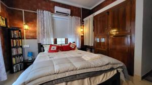 a bedroom with a large bed with red pillows at The Brick Nest in Perumpāvūr