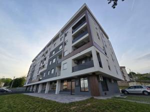 a large building with a car parked in front of it at Modern Apartment Laktaši in Laktaši