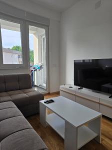 a living room with a couch and a flat screen tv at Modern Apartment Laktaši in Laktaši