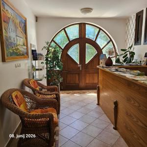a kitchen with a large wooden door and wicker chairs at B&B Na Kluk in Idrija