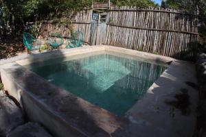 a pool of water in a backyard with a fence at Casa Ake in Aké