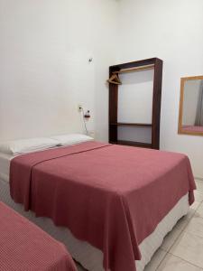 a bedroom with two beds with a red blanket at Casa Paraíso Guajiru in Trairi