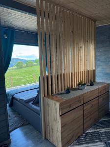 a room with a bed and a wooden wall at Old Man's Cabin in Măguri