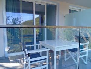 a white table and chairs in a room with a window at Poseidon Complex in Paleokastritsa +53 photos