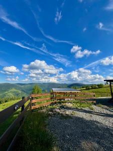 a wooden fence with a view of the mountains at Old Man's Cabin in Măguri