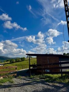 a wooden building in a field with a fence at Old Man's Cabin in Măguri