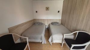 a small room with two beds and two chairs at Parko Studija in Birštonas