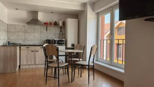 a kitchen with a table and chairs in a room at Parko Studija in Birštonas
