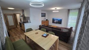 a living room with a couch and a table at Alpina Sonnen-Appartements Füssen incl XL-Sonnen-Terrasse & Königscard in Füssen