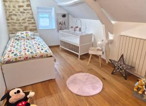 a childs bedroom with a bed and a crib at Chambre Colomby Kaabi in Colomby +10 photos