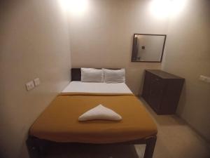 a small bed in a small room with a mirror at ZOLO Stays in Chennai