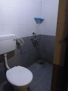 a bathroom with a white toilet and a shower at ZOLO Stays in Chennai +6 photos
