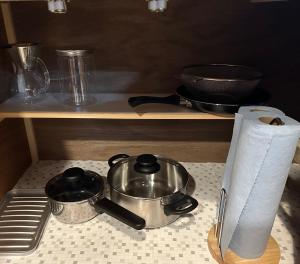 a kitchen counter with two pans and a roll of paper towels at Lodge Kurokawa 1 in Minamioguni