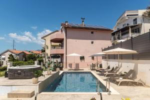 a swimming pool in front of a building at Apartments Kuc in Tivat