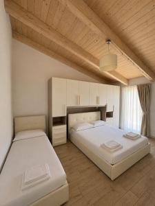 a bedroom with two beds and a wooden ceiling at Casa vacanze indipendente in Follonica