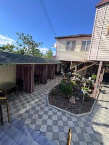 a patio with a garden in front of a house at Гостевой дом Надежда in Zatoka