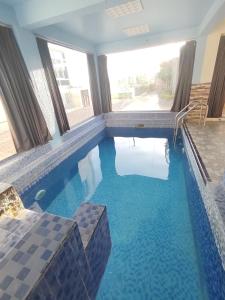 a swimming pool with blue water in a house at Rosa mountain reast in Al ‘Aqar