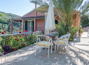 a table and chairs with an umbrella in front of a house at Ilia's Holiday Home in Perítheia