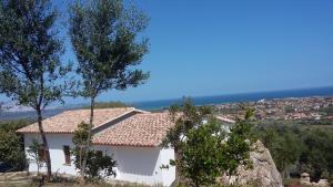a white house with a view of the ocean at KaraA'mare in San Teodoro