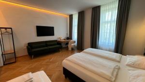 ein Hotelzimmer mit einem Bett und einer Couch in der Unterkunft Kolbeck Rooms in Wien