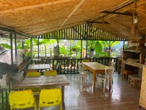 a dining room with a table and yellow chairs at KARTSIVADZe in Ureki