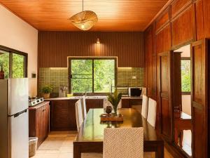 a kitchen with a table and a refrigerator at Hidden Home Samui in Koh Samui