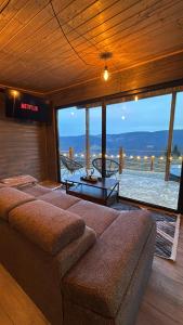 a living room with a couch and a view of the ocean at Old Man's Cabin in Măguri +8 photos