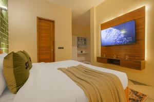 a bedroom with a white bed and a flat screen tv at Stay XO - A Luxurious 3BHK Villa in Panchkula in Panchkula