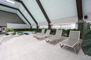 a group of chairs on a patio with plants at Paxtonz Exsim By NexxField in Petaling Jaya