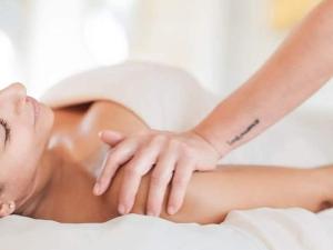 a woman laying on a bed with a tattoo on her arm at מול הים in Moreshet