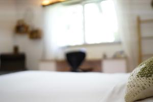 a bedroom with a white bed with a window at The Comfy Apartment in Ponte Capriasca